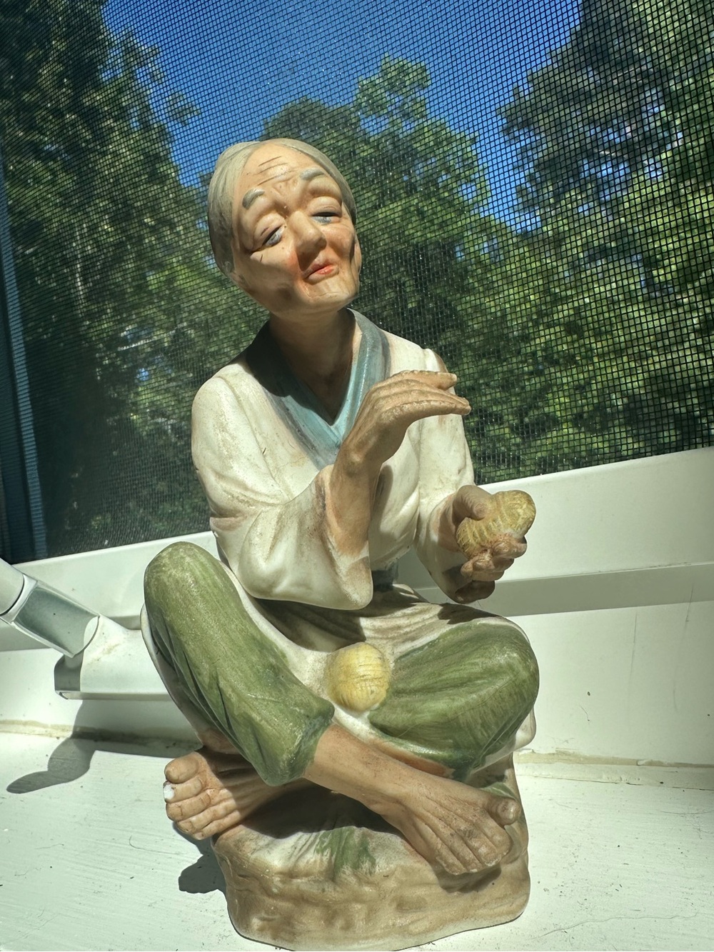 Bisque porcelain Napcoware figurine of an elderly women holding a nut